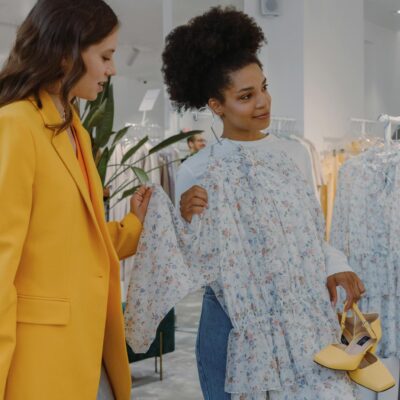Two women shopping for stylish clothing in a modern fashion boutique.
